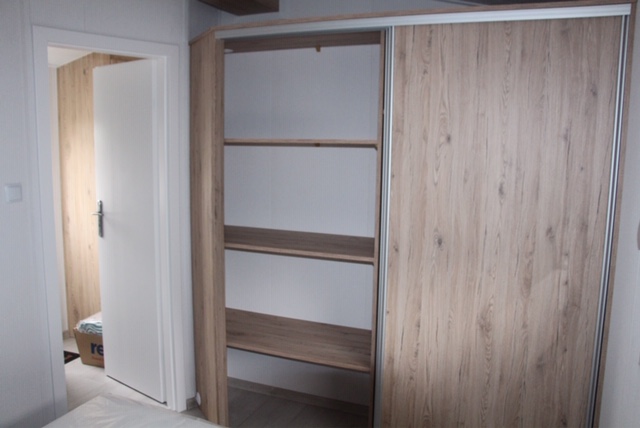Am Fußende des Bettes im Haupt-Schlafzimmer ist ein großer Wandschrank mit genügend Platz für die Kleidung